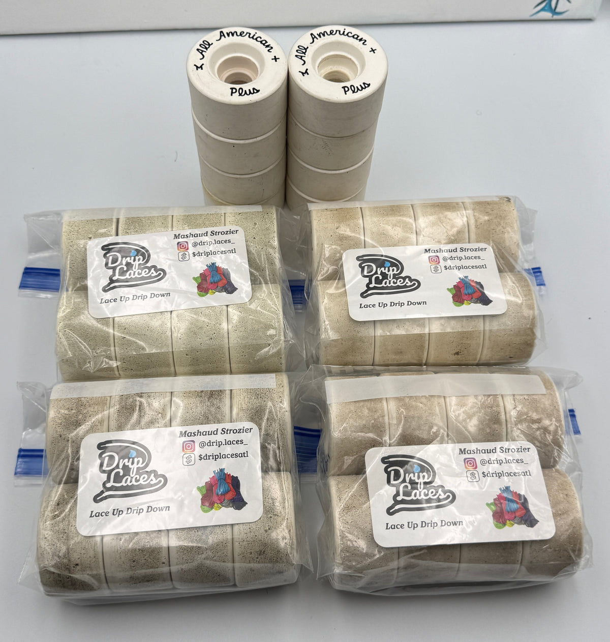 Four packages of OG All American Plus Roller skate wheels on a white surface.