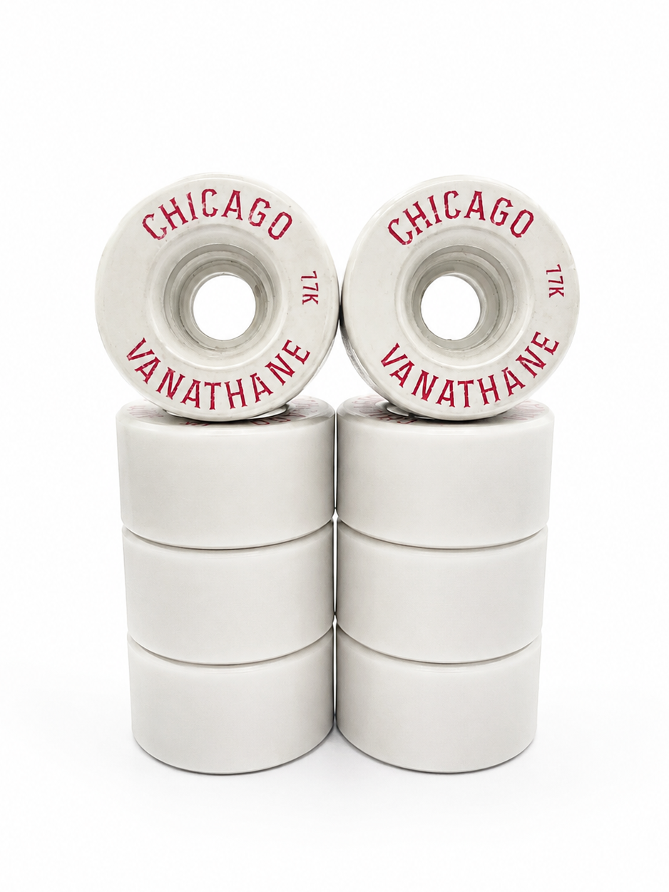 Six white skateboard wheels stacked in two columns of three, with two wheels on top showing red printed text that reads 'CHICAGO' and 'VANATHANE'.